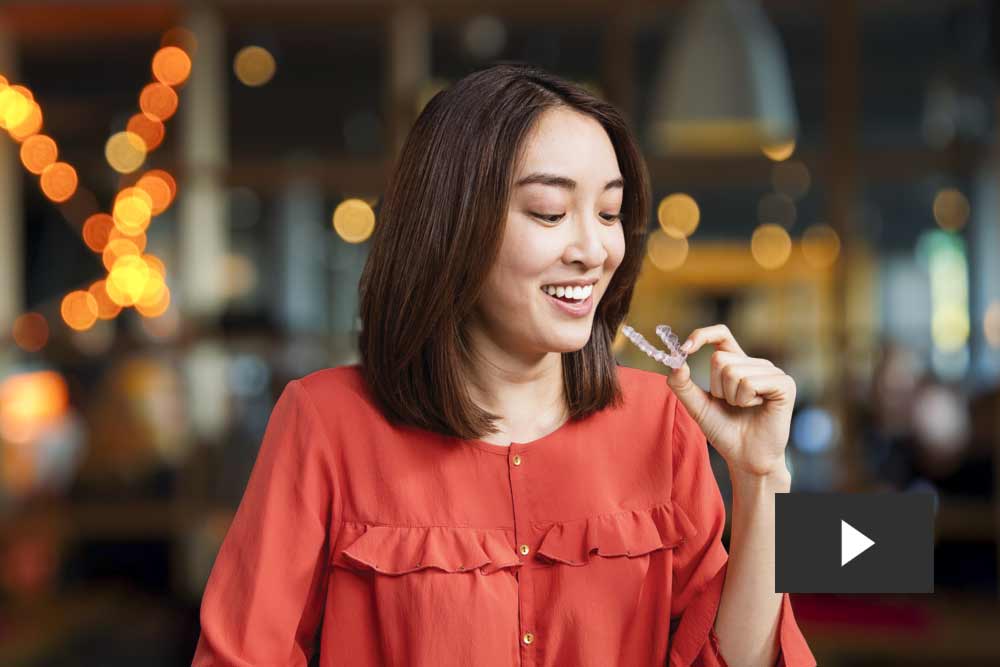 Woman putting in clear aligners