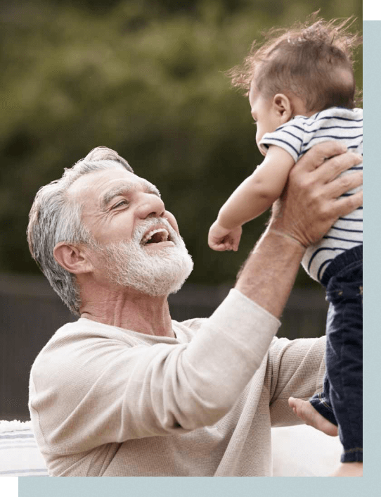 Older man holding up a baby